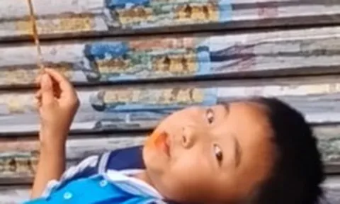 Mẹ đến đón muộn, cậu bé thản nhiên nằm trên bậc thềm ăn đồ ăn: Dân mạng bật cười vì quá chill!